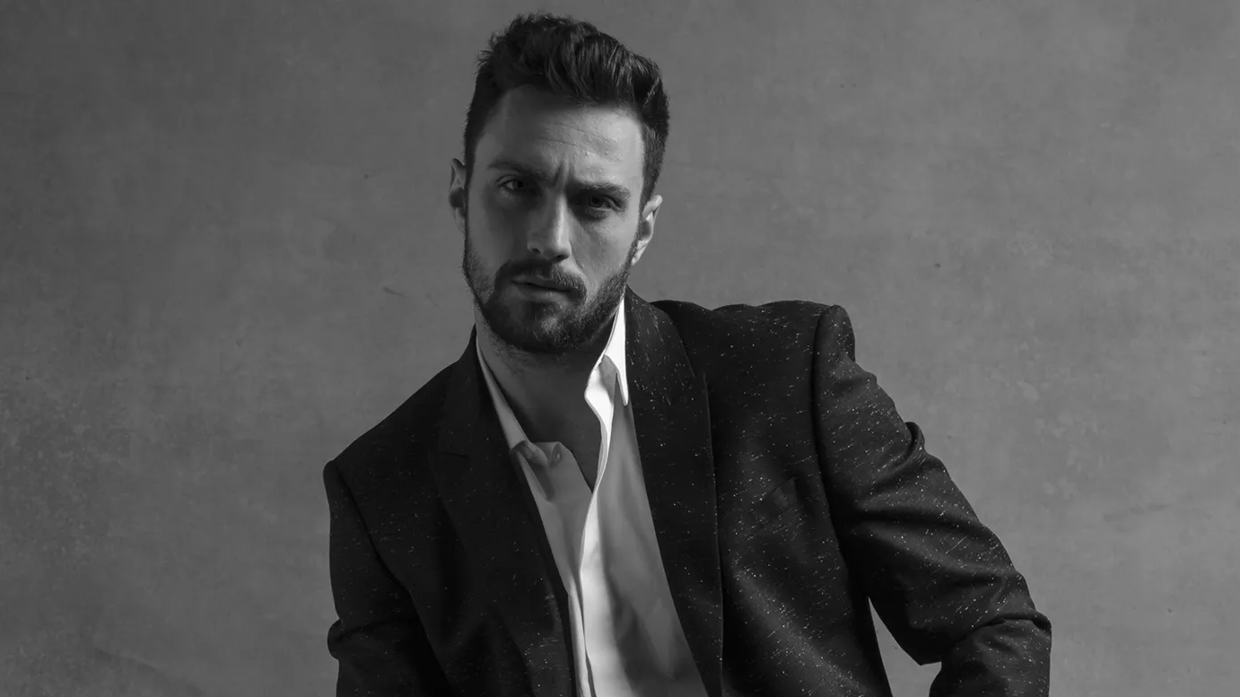 Aaron Taylor-Johnson posing as James Bond in black and white image